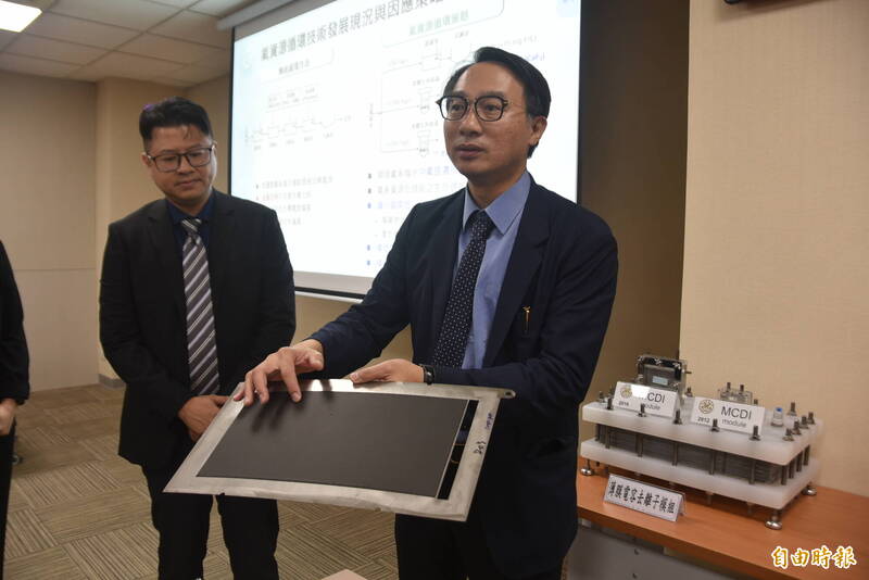 台大環工所特聘教授侯嘉洪展示用石墨片製成的薄膜電容,可將含氟離子以電化學方式去污及濃縮,避免加藥劑增加廢水處理成本及碳排放等。(記者吳柏軒攝)