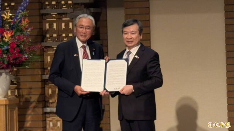 「日本台灣友好議員聯盟」會長古屋圭司（左），將今年該會的基本方針案遞交給駐日代表李逸洋（右）。（記者林翠儀攝）