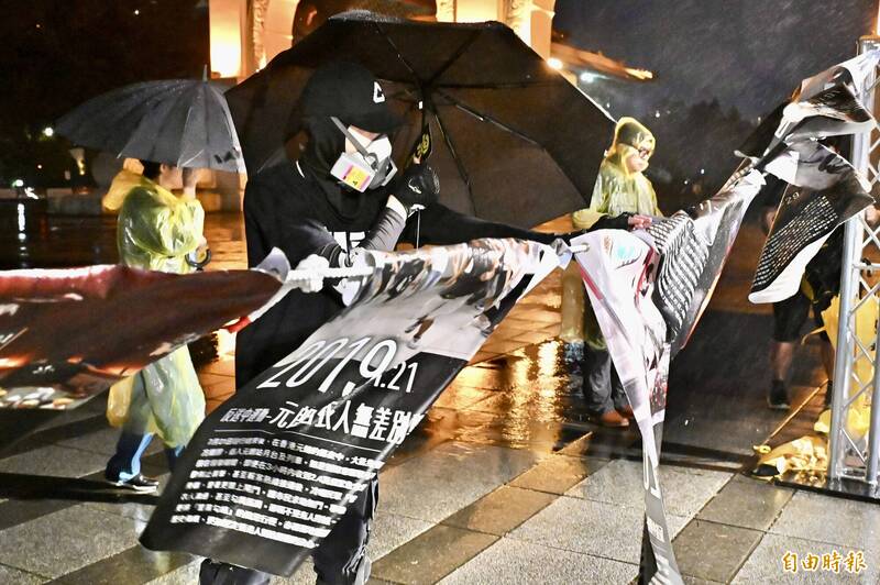 民眾帶著防毒面具觀看香港抗爭歷史牆。（記者塗建榮攝）