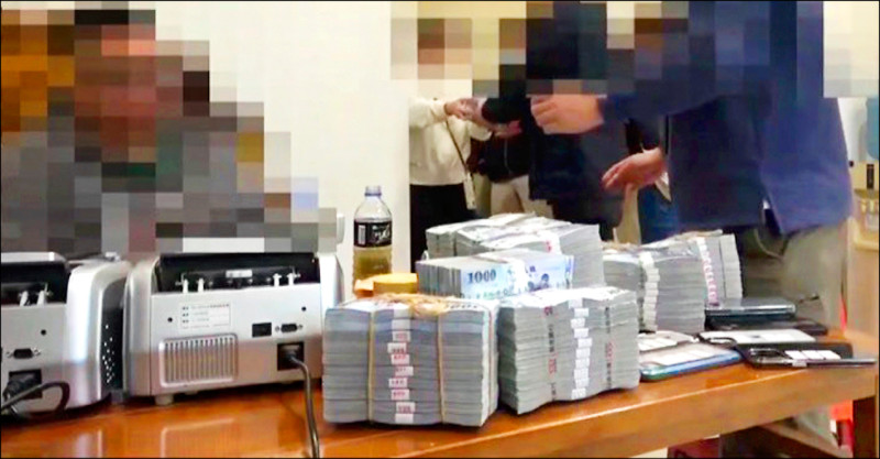 警方搜索台中一家精品當舖，塞爆保險箱的鈔票傾瀉而出。（警方提供）