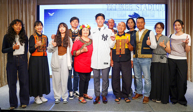 Taiwanese pitching prospect Lai Chien-fan, sixth left, poses with family and friends at a signing ceremony in Taipei yesterday after inking a contract with the New York Yankees.
Photo: CNA