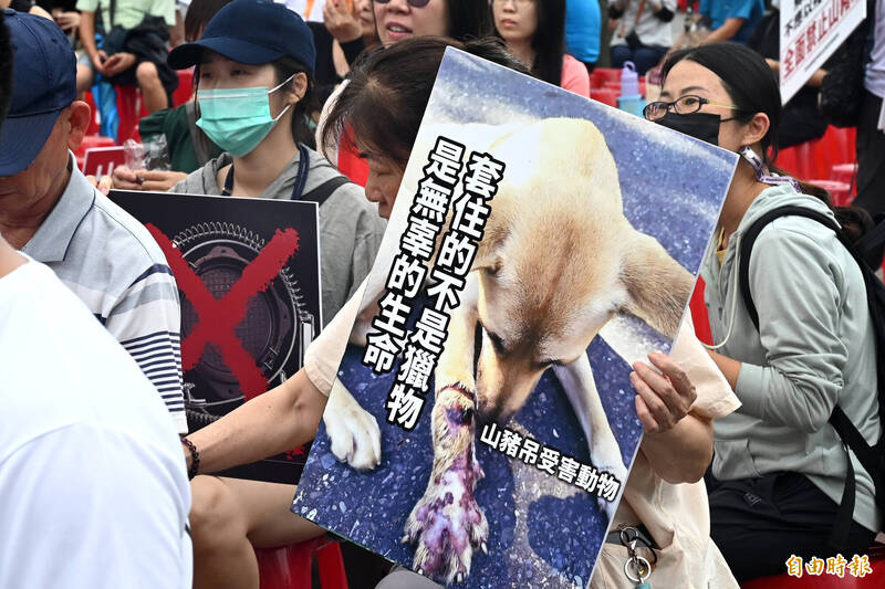 愛護動物人士手拿海報，上面寫著山豬吊「套住的不是獵物，是無辜的生物。（記者王藝菘攝）