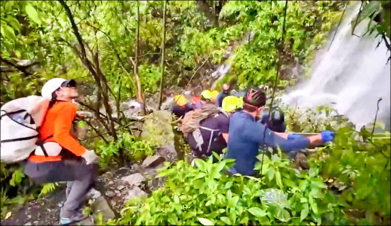 台中市和平區蝴蝶谷瀑布步道昨日下午發生重大山難，大量落石突然崩落，瞬間砸中多名團員造成4死一傷，搜救人員冒雨搶救。（消防局提供）
