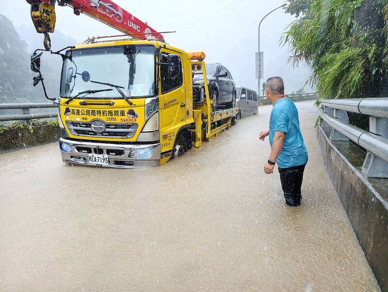 Heavy rain and strong winds brought by Typhoon Bavi caused severe flooding on Miaoli County’s Road 62 yesterday.
Photo: CNA
