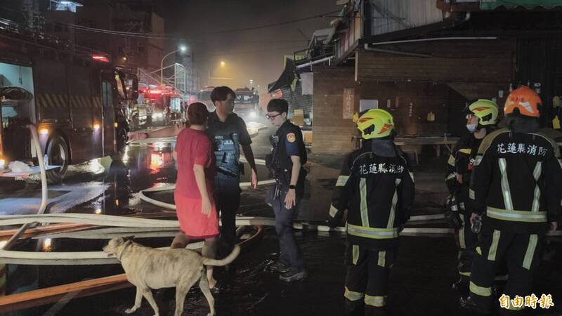 花蓮市重慶市場旁邊的四連棟鐵皮屋今天0點發生火災，被愛犬來福叫醒的林女士在一旁呼喊愛犬的名字，阿爆緊跟在旁。（記者王錦義攝）