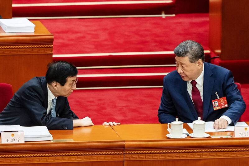 中國國家主席習近平(右)與政協主席王滬寧(左)交談。(彭博資料照)