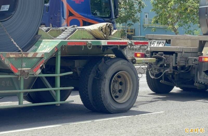 高雄小港一辆载运钢卷拖板车，后轮胎已经严重损坏，但还是依旧行驶在道路上相当危险。（记者李惠洲摄）