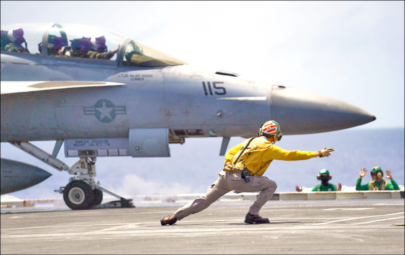 羅斯福號上的甲板彈射官向F/A-18戰機飛行員下達彈射起飛命令。(法新社)