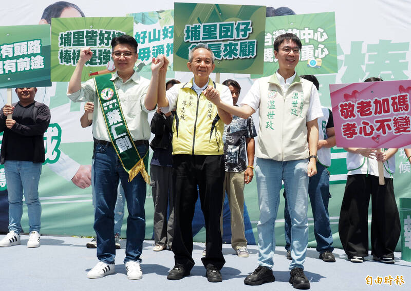 埔里鎮長廖志城（中）牽起埔里鎮長參選人葉仁創（左）、南投縣長參選人温世政（右）的手一起高喊凍蒜。（記者陳鳳麗攝）