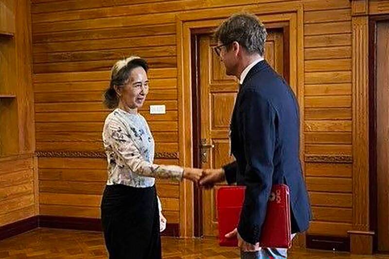 翁山蘇姬與巴埃克握手。（法新社）