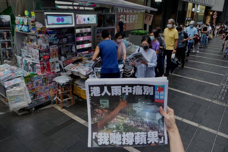 2021年6月24日，大批香港民眾在報攤前排隊購買最後一期的《蘋果日報》。（美聯社資料照）