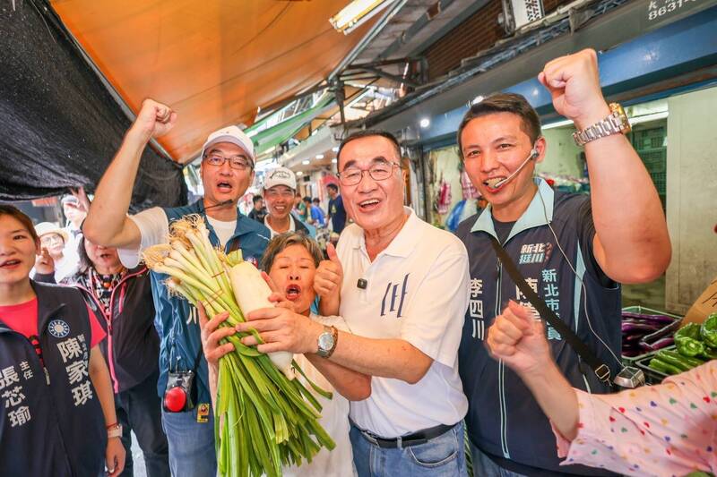 李四川淡水市場掃街 攤商熱情送鳳梨菜頭喊凍蒜 民眾搶合照
