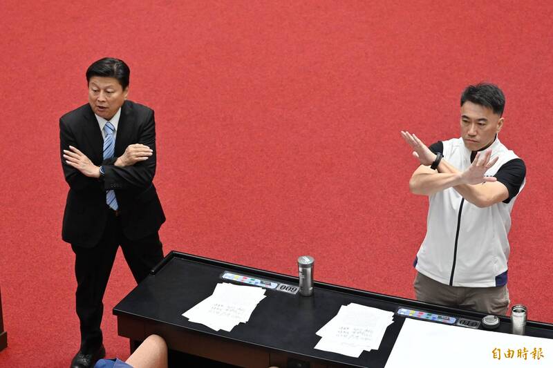 立法院院會今（14日）審查中央政府總預算案，國民黨團總召傅崐萁與書記長林沛祥（右）胸前比叉指示黨團立委棄權投票。（記者陳逸寬攝）