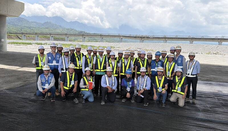 副總統蕭美琴與公路局玉里大橋工程團隊合影，背景的橋樑是台鐵舊秀姑巒溪大橋，目前為自行車道，橋墩還明顯可見斷層造成的錯位。（公路局提供）