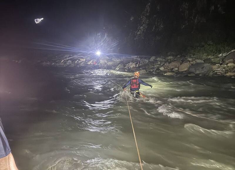 巴陵消防分隊隊員、義消架好繩索後，強渡到對岸救出釣客。（巴陵分隊提供）