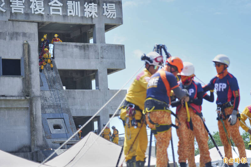 菲律賓與我國救災人員演練進入坑道救援，遠方則是我特搜人員在倒塌建物中救出受困者。（記者劉人瑋攝）