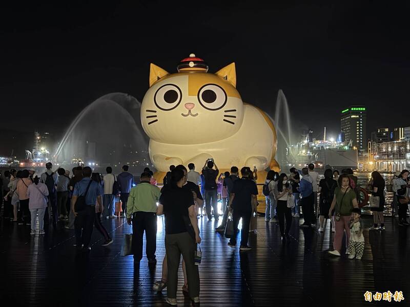 「黃阿瑪的後宮生活」大型水上氣球今天晚上舉行點燈開幕儀式，海洋廣場湧入不少民眾搶拍。（記者俞肇福攝）