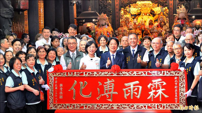 總統賴清德（前排右五）代表人民致贈匾額「霖雨溥化」給新莊慈祐宮，祈祝蘇巧慧（前排右六）當選。?（記者黃政嘉攝）