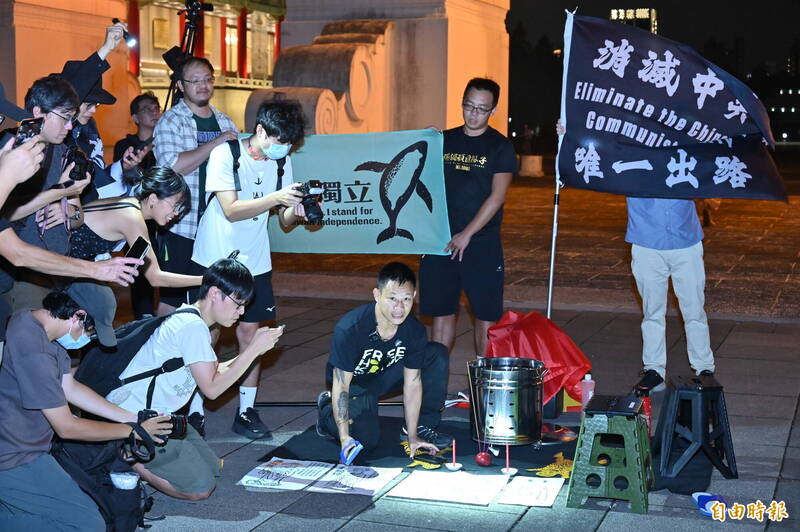 地上擺放中國國家主席習近平等人畫像敲打「打小人」。（記者叢昌瑾攝）