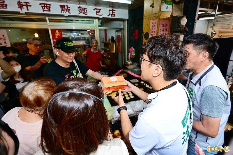 沈伯洋走訪市場掃街時，支持者熱情送上一盒西點及一袋點心。（記者陳逸寬攝）
