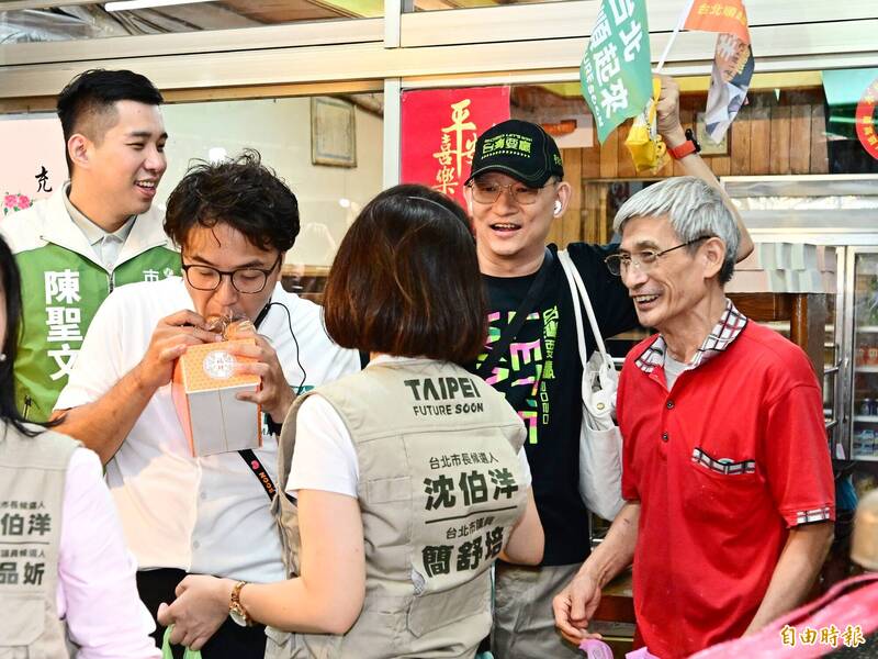 拍完照後，沈伯洋忍不住當場「偷吃」一個。（記者陳逸寬攝）