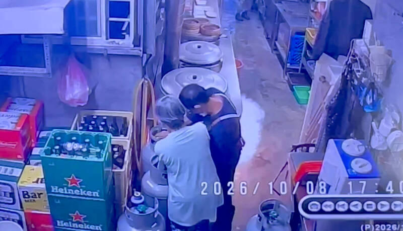 2店員更換鋼瓶，一旁爐灶下先冒火光。（民眾提供）