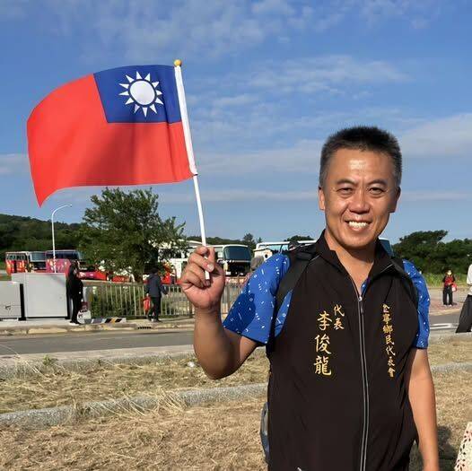 获全国防救灾最高荣誉「凤凰奖」的李俊龙，近日频频接到祝贺声，他拿著国旗开心祈祝国泰民安。（撷自李俊龙脸书）
