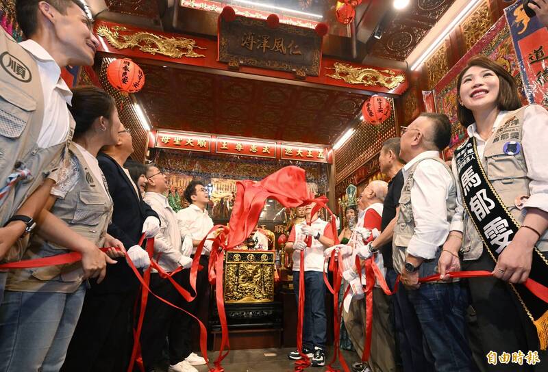 沈伯洋與徐國勇等人拉下紅布條，揭幕總統賴清德題字的「仁風澤溥」匾額。（記者林正堃攝）