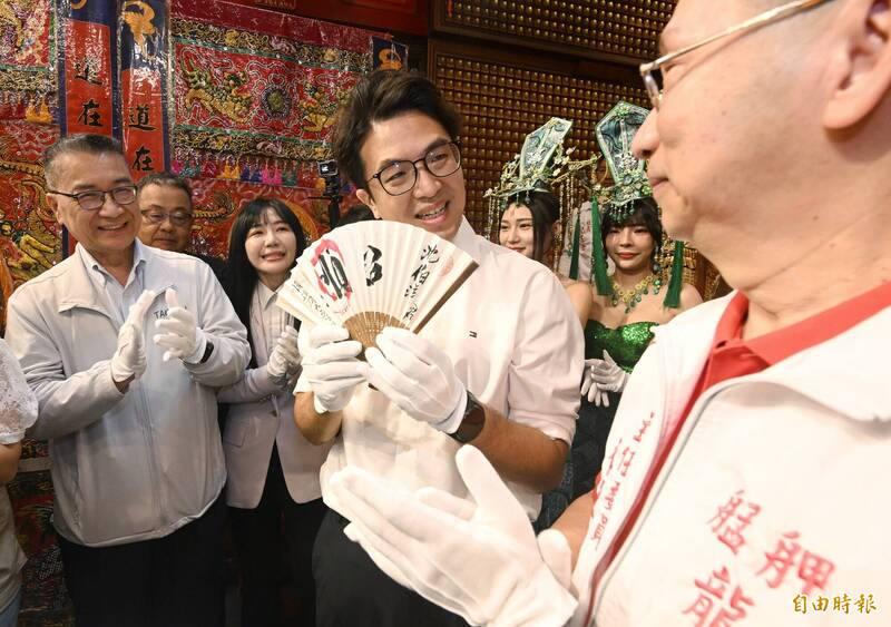 沈伯洋展示手上的應援折扇，上頭寫著「沈伯洋」與「順」字，一旁的徐國勇微笑鼓掌。（記者林正堃攝）