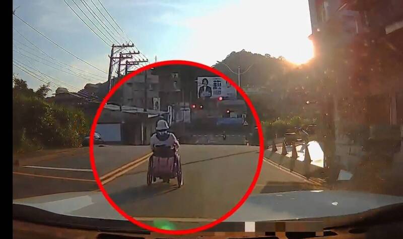 妇人坐著电动轮椅在大马路上与车争道。（民众提供）