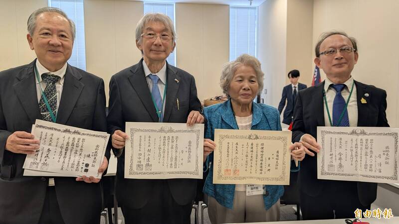 與會台僑中里憲文（左1）、廣內世英（左2）等人秀出證照，被標示「中國」籍。（記者林翠儀攝）