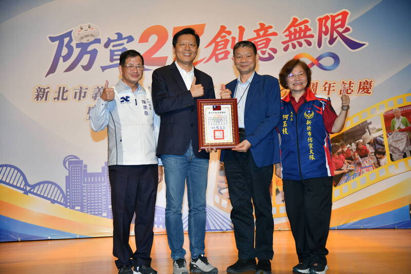 新北市义消总队为防火宣导大队27周年举办「能量汇聚、守护新北」仪式，副市长朱惕之（左2）、消防局长陈崇岳（左1），颁状感谢消防安全基金会董事长陈文龙（右2）。（记者吴仁捷翻摄）