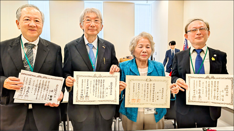 與會台僑中里憲文(左1)、廣內世英(左2)等人秀出原有被迫登記為「中國」的證照。(駐日特派員林翠儀攝)