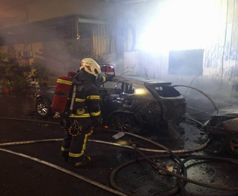 消防員全力搶救工廠大火，倉庫外的汽車遭焚毀。（消防局提供）