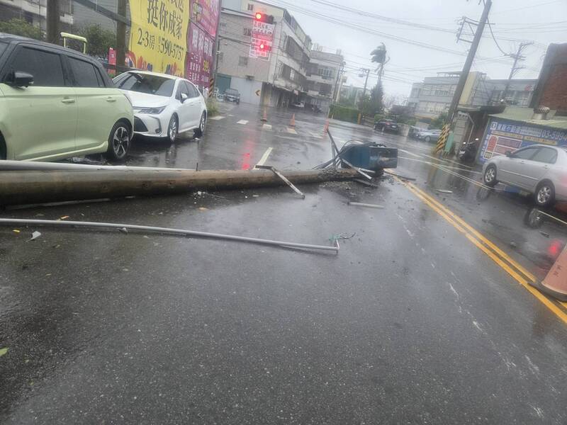 湖口鄉德興路架在電桿上的微型基地台，應聲傾倒橫躺在馬路上，造成停放路邊的轎車受損，所幸當時沒有人車行經。（吳淑君提供）