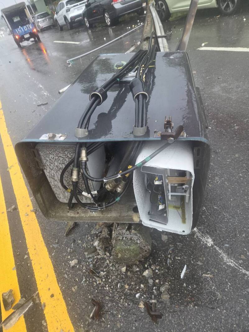 湖口鄉德興路架在電桿上的微型基地台，應聲傾倒橫躺在馬路上，造成停放路邊的轎車受損，所幸當時沒有人車行經。（吳淑君提供）