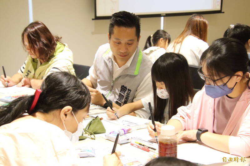 民進黨竹北市長候選人曾聖凱讓小朋友自由塗鴉，但在小朋友求助時適時指導如何運筆。（記者黃美珠攝）