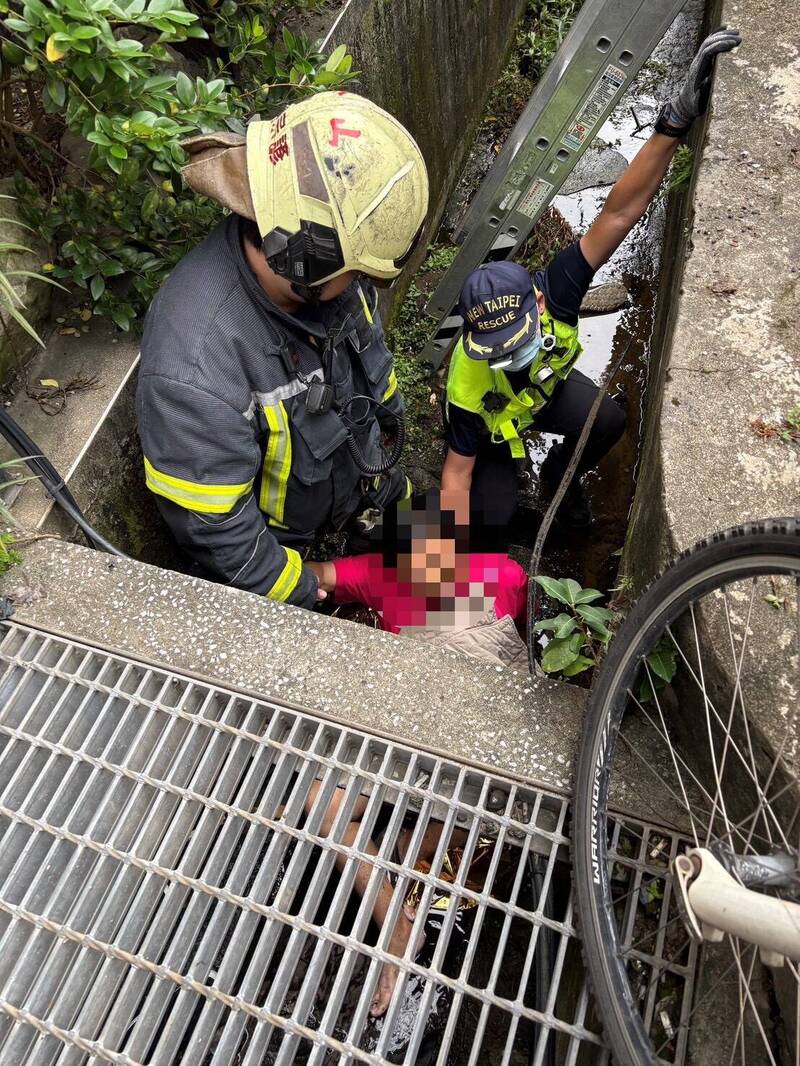 警消合力將掉落水溝的老婦救出。（記者徐聖倫翻攝）
