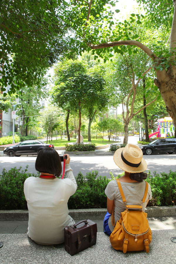 隨意坐在人行道旁的台階或椅子上，望向富錦街上的公園，偶爾會傳來孩子嬉鬧聲，感受日常生活的緩慢風景。