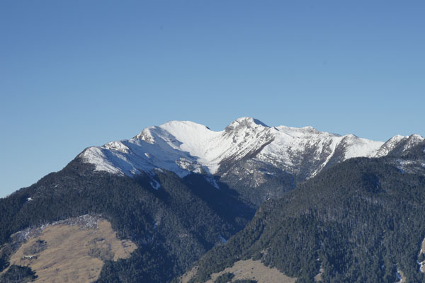 遙望雪山主峰一片白皚皚雪景，山頭中間凹槽即為鞍部，下方如碗狀即是圈谷。