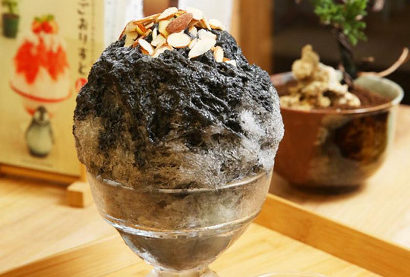 芝麻刨冰使用台灣在地芝麻磨成醬，淋在堆疊成山的刨冰上，冰裡除了放有綜合堅果外，上頭也放有杏仁片，有邊吃冰邊挖寶的樂趣。