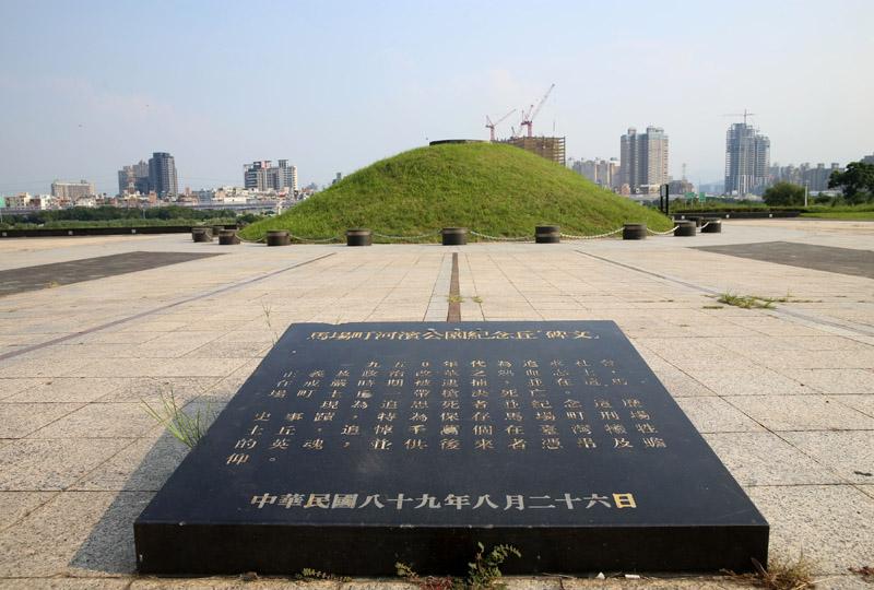 公園中央有一座紀念土丘，前方的黑色紀念碑寫了紀念緣由。（記者臺大翔／攝影）