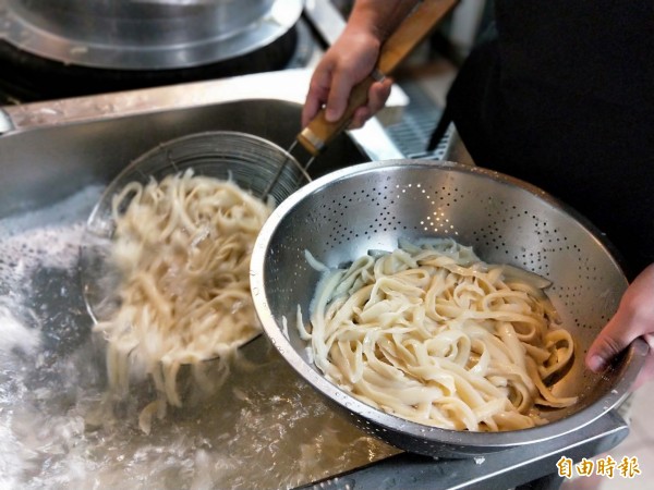 滾水煮熟的麵條放入冷水冰鎮後，撈起備用。（記者何玉華攝）