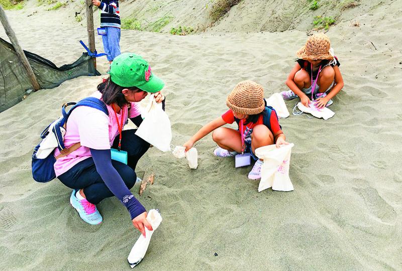 大家趕快收集海沙，下午才能用海沙混和白飯做成「海客彈珠」。（圖片提供／笨港國小）