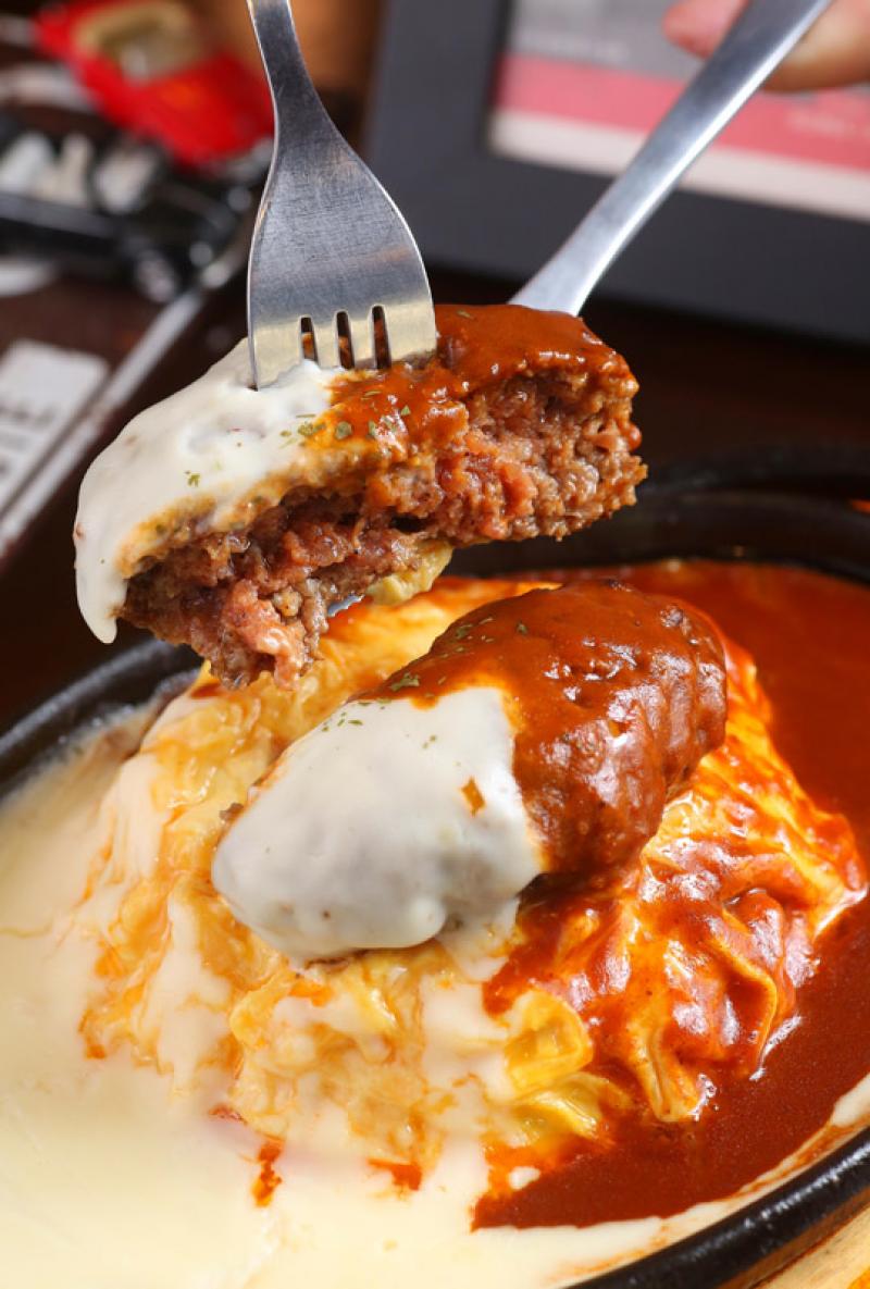鐵板雙醬漢堡排蛋包（牛肉）／220元，牛肉漢堡排先煎再烤，搭配的海鮮白醬是以牛奶、鮮奶油等不加水煮製，紅酒燉牛肉醬則以蔬菜、牛肉和紅酒等熬煮，蛋包飯裡為蔬菜、肉絲炒飯，有著多層次的濃郁風味。（記者潘自強／攝影）