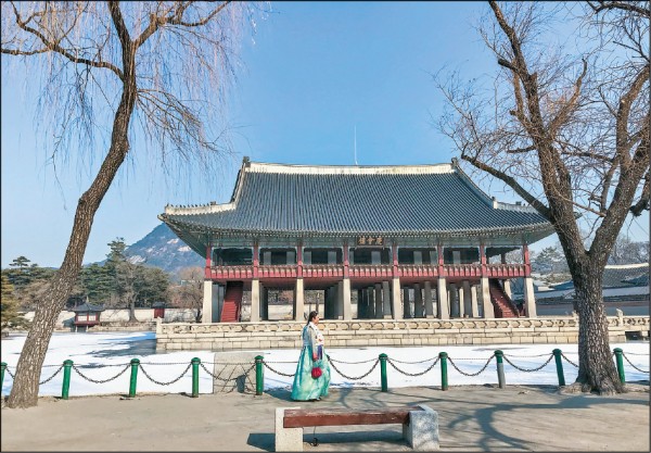 穿韓服的遊客走過景福宮慶會樓，彷彿進入時光隧道。