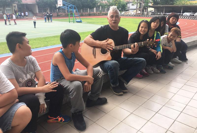 陳永淘在南庄國小自彈自唱自己創作的客家歌曲。（記者鄭名翔攝）