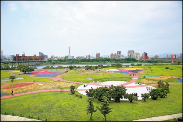 公園靠近水門這側有座觀景台，可站在高處、輕鬆用鏡頭補捉整個公園景致，也可欣賞完整地景襯著河岸與城市的風光。（記者沈昱嘉／攝影）