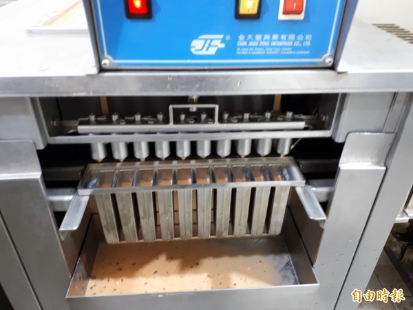 新竹市「814大同冰店」採傳統製冰方式，冰棒都是裸冰棒出售，沒有過多包裝，且使用竹子撐著冰棒，所有製冰棒過程都公開透明，一次最多可製600支冰棒，且透過脫冰機，須在1分鐘內裝袋完成。（記者洪美秀攝）