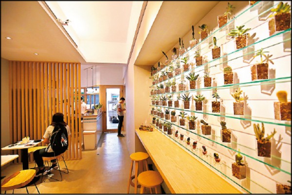 店內提供舒適清爽的吃冰空間，牆面上以冰杯製作成盆栽擺飾，顧客吃完也可自行帶回空杯，仿店家環保作法種植多肉植物或做成小盆栽。（記者潘自強／攝影）